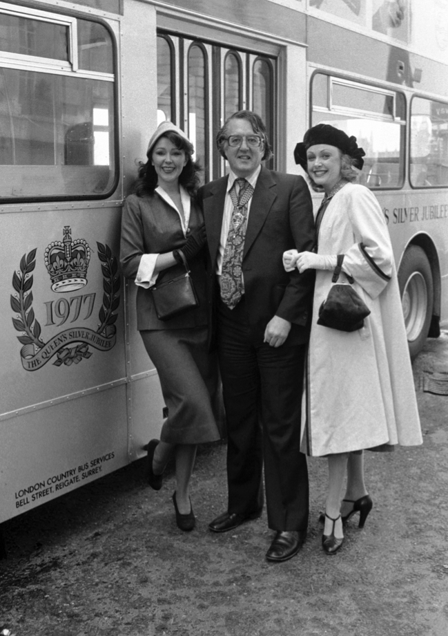GLC Chairman Lord Ponsonby is flanked by models Lina Hooks, left, and Jan Emery - both dressed in the attire of 1952 - as he introduces the first of 50 silver buses celebrating the silver jubilee